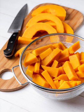 Beyaz ahşap zemin üzerinde kase dilimlenmiş Turuncu kabak görünümü Kapat