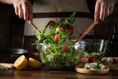 Taze yeşil salata domates ve brie peyniri cam kase ile karıştırma adam