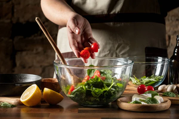 Man Mengen Frisse Groene Salade Met Tomaten Brie Kaas Glazen — Gratis stockfoto