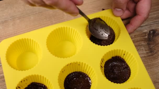 冷凍デザートのための黄色のシリコーン型にチョコレートパン粉を入れる男の近いビュー — ストック動画