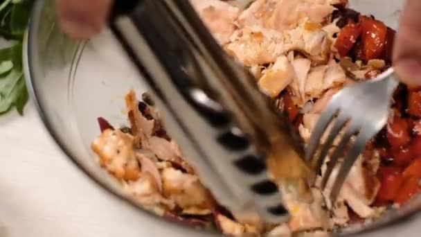 サラダのために新鮮な焼きサーモンの魚を刻む男の近くの眺め — ストック動画
