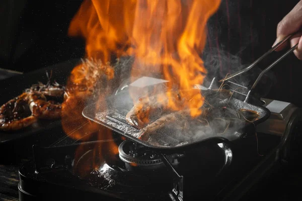 Som Håller Grillning Pan Med Brinnande Kryddiga Räkor — Stockfoto