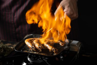 Tavada yanan otlar ile baharatlı karides yakın görünümü