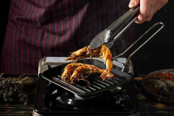 Blízký Pohled Kuchaře Grilovanými Krevetami Kuchyňskými Kleštěmi — Stock fotografie