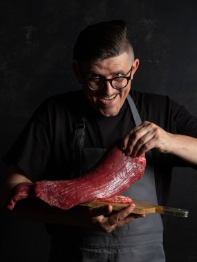 Şef çiğ et tutuyor. 