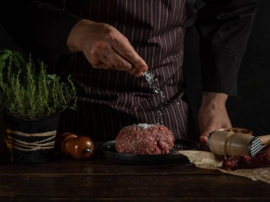 Şef baharat ve otlarla kıyma hazırlıyor.