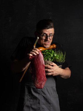 Şef çiğ et tutuyor. 