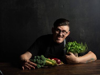 Elinde taze sebze tutan bir adam.