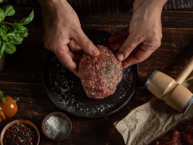 Şef baharat ve otlarla kıyma hazırlıyor.