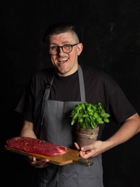 Şef çiğ et tutuyor. 