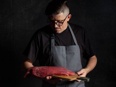 Şef çiğ et tutuyor. 