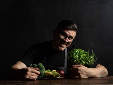 Elinde taze sebze tutan bir adam.