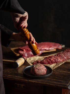 Şef baharat ve otlarla kıyma hazırlıyor.