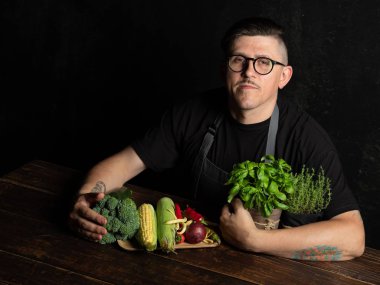 Elinde taze sebze tutan bir adam.