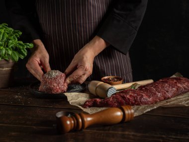 Şef baharat ve otlarla kıyma hazırlıyor.