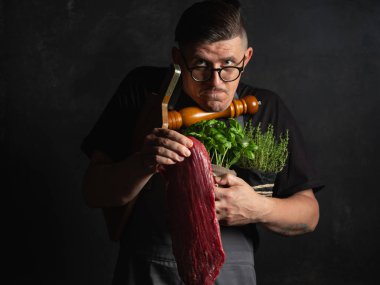 Şef çiğ et tutuyor. 