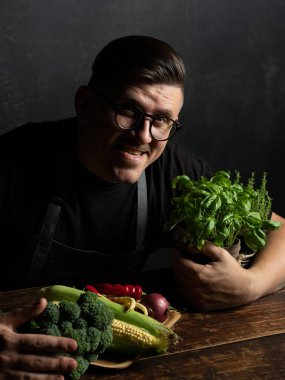 Elinde taze sebze tutan bir adam.