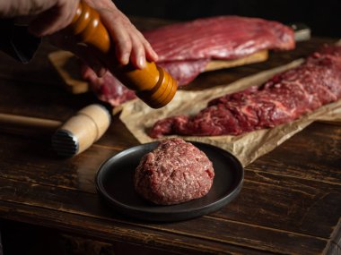 Şef baharat ve otlarla kıyma hazırlıyor.