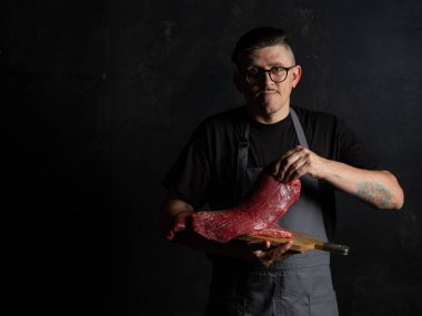 Şef çiğ et tutuyor. 