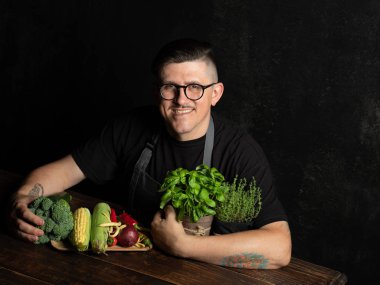 Elinde taze sebze tutan bir adam.