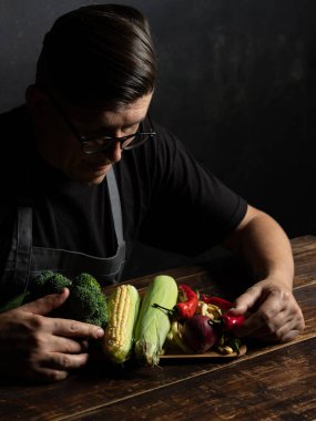 Elinde taze sebze tutan bir adam.