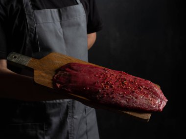 Şef çiğ et tutuyor. 