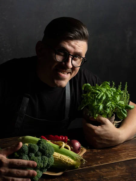 Elinde taze sebze tutan bir adam.