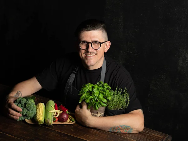 Elinde taze sebze tutan bir adam.