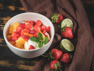 Taze böğürtlenli meyve salatası, narenciye, meyve ve dondurmayı arka planda karışık malzemelerle servis ediyoruz. Sağlıklı ve diyet gıda konsepti