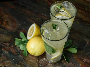 Limon dilimleri ve nane yapraklı mojito kokteylleri. 