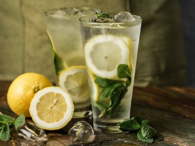 Limon dilimleri ve nane yapraklı mojito kokteylleri. 
