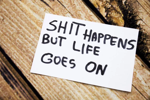 Shit happens but life goes on handwritten message on white paper with retro wooden bark background. Motivational handwritten messages on paper with retro background. — Stock Photo, Image