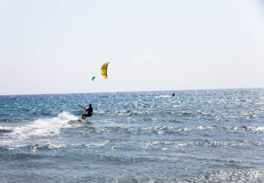 Etkin adam Kitesurfing uçurtma ile sahilde. Aşırı su sporları. Yaz tatil eğlence zamanı. Kiteboarding. Dalga eylem içinde profesyonel uçurtma sörfçü
