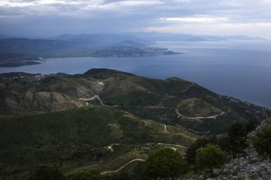 Beyaz yollar gümüş kolye gibi onları için hareket çok küçük tepeler. Tepelerde gördüğümüz bazı binalar ve arka tarafta tepeler sis ve deniz önündeki ile kaplı. 