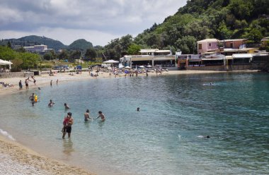 İnsanlar alarak güvenli bir şekilde beach Nikos Taverna restoran önünde banyo. Plaj Restoran bar, otopark yer, Steak House, Snack Bar ve Yunan mutfağı spesiyaliteleri sunar.