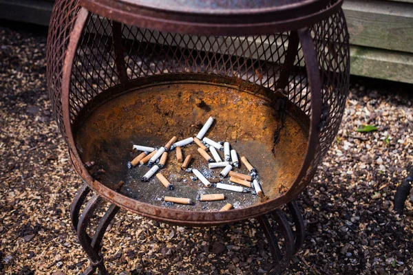 İle dolu ashtrey kullanılan ve sigara filtreleri füme. Çöp filtrelerde kullanılan puro ile sağlıksız ve kirli kavram olabilir. Paslı ve kirli çöp sigara filtreleri ile