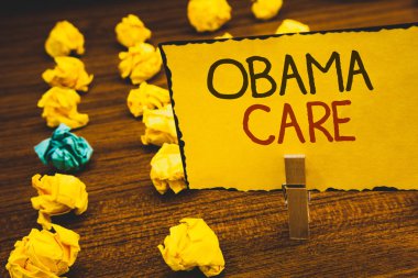 El yazısı metinler Obama bakım. Hükümet programı, sigorta sistemi hasta sarı kağıt fikirler buruşuk kağıtlar ahşap arka plan holding Protectionclothespin anlam kavramı