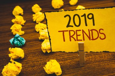 El yazısı metinler 2019 eğilimleri. Moda değişiklikleri yenilikleri Modernclothespin holding sarı kağıt fikirler buruşuk kağıtlar ahşap arka plan gelişmeler yeni yıl anlam kavramı