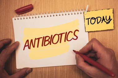 Metin işaret gösteren antibiyotik. Kavramsal fotoğraf ilaç tedavisi ve bakteriyel infectionsman bugün dizüstü el için oluşturma önlenmesinde kullanılan basılı tutarak kalem ahşap arka plan