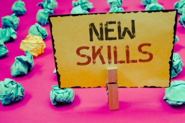 Kavramsal el yeni beceriler gösterilen yazma. Son zamanlarda satın öğrendim yetenekleri bilgi Competencesclothespin tutun sarı kağıt fikirler buruşuk Kağıt tutan vitrine iş fotoğraf