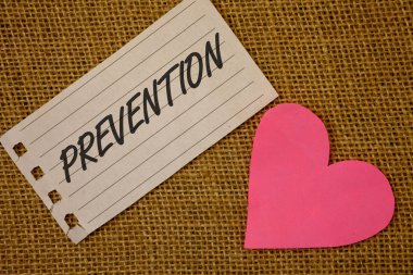 Önleme gösterilen metin işareti. Kavramsal fotoğraf olay sağlık Protectionnotebook sayfasından hasır arka plan pembe kalp siyah kırmızı harfler aşk notu bir şey durdurma