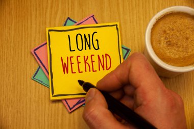 Uzun hafta sonu gösterilen metin işareti. Kavramsal fotoğraf kısa tatil tatil sezonu rahatlatıcı rekreasyon timeman sarı pembe mavi kağıtları el holding siyah kalem kahve fincan oluşturma