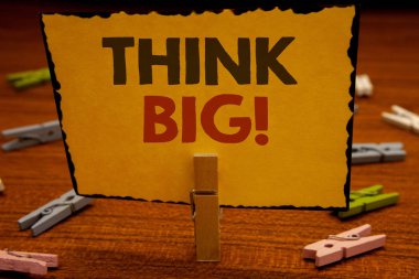 Metinler yazma kelimeler büyük motivasyon çağrı düşünüyorum. İş kavramı için büyük fikirler bir şey hayalini amazingclothespin tutun clothespins ahşap arka plan sarı kağıt fikirler tutan var