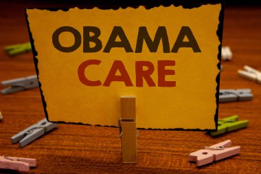 Metinler Obama bakım yazma kelimeler. Hükümet programı, sigorta sistemi hasta Protectionclothespin için iş kavramı tutun clothespins ahşap arka plan sarı kağıt fikirler holding