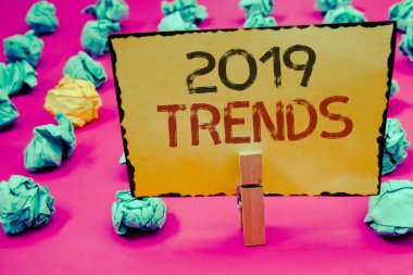 Kavramsal el 2019 Trendler gösterilen yazma. Sarı kağıt buruşuk fikirler kağıtları holding iş fotoğraf vitrine yeni yıl gelişmeler moda değişiklikleri yenilikler Modernclothespin tutun