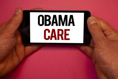 Kavramsal el Obama bakım gösterilen yazma. Cep telefonu beyaz ekran siyah kırmızı harflerle tutan hükümet programı, sigorta sistemi hasta Protectionman tutun vitrine iş fotoğraf