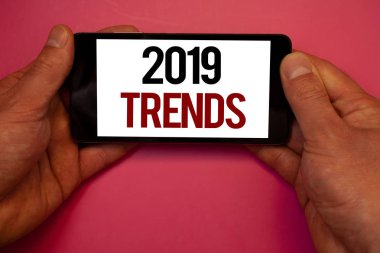 Kavramsal el 2019 Trendler gösterilen yazma. Moda değişiklikleri yenilikler Modernman tutun cep telefonu beyaz ekran siyah kırmızı harflerle tutan gelişmeler yeni yıl vitrine iş fotoğraf