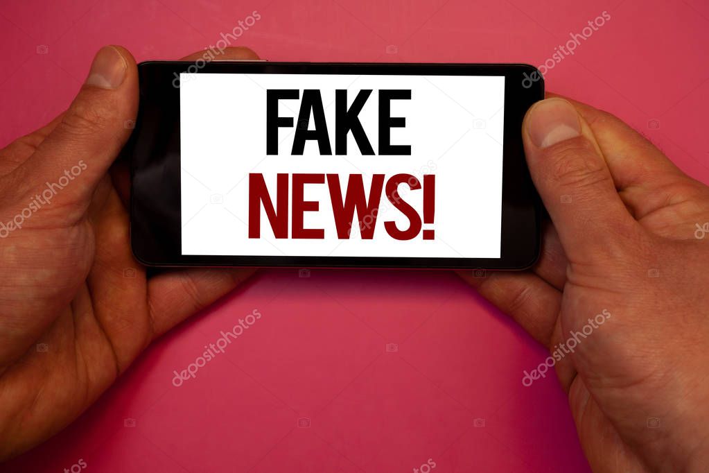 Conceptual hand writing showing Fake News Motivational Call. Business photo showcasing False Unsubstantiated Information HoaxMan hold holding cell phone white screen black red letters pink background
