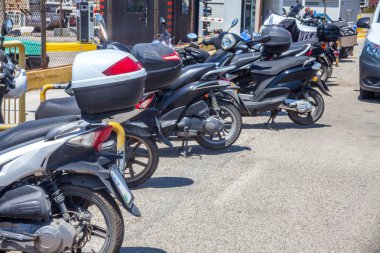 Paleokastritsa, 10 Mayıs 2018 yılına kadar kazık yol kenarı parlak güneşli gün boyunca Cofru, Yunanistan - motosiklet. İki tekerlekli araç parkları metal çit. Tarafından geçen araba