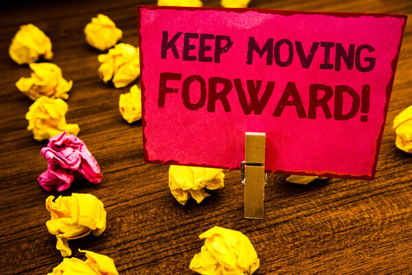 Conceptual hand writing showing Keep Moving Forward Motivational Call. Business photo showcasing Optimism Progress Persevere Move Paperclip retrain pink card with letters wooden floor hunch